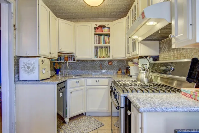 a kitchen with stainless steel appliances granite countertop a sink stove and cabinets