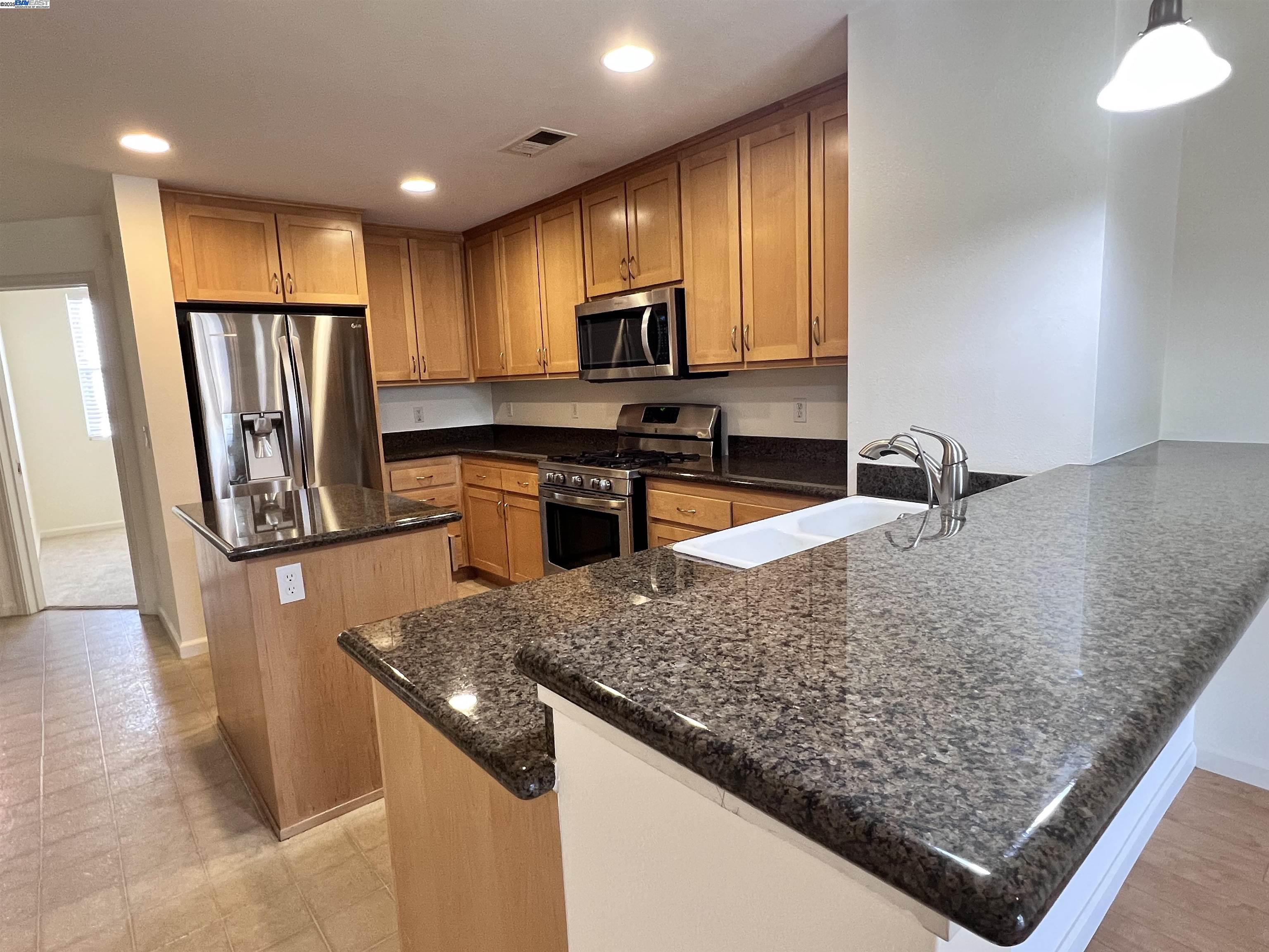 4331 Westerly Common Fremont, CA 94538 - Photo 7 of 24 a kitchen with stainless steel appliances granite countertop a sink a stove and a refrigerator