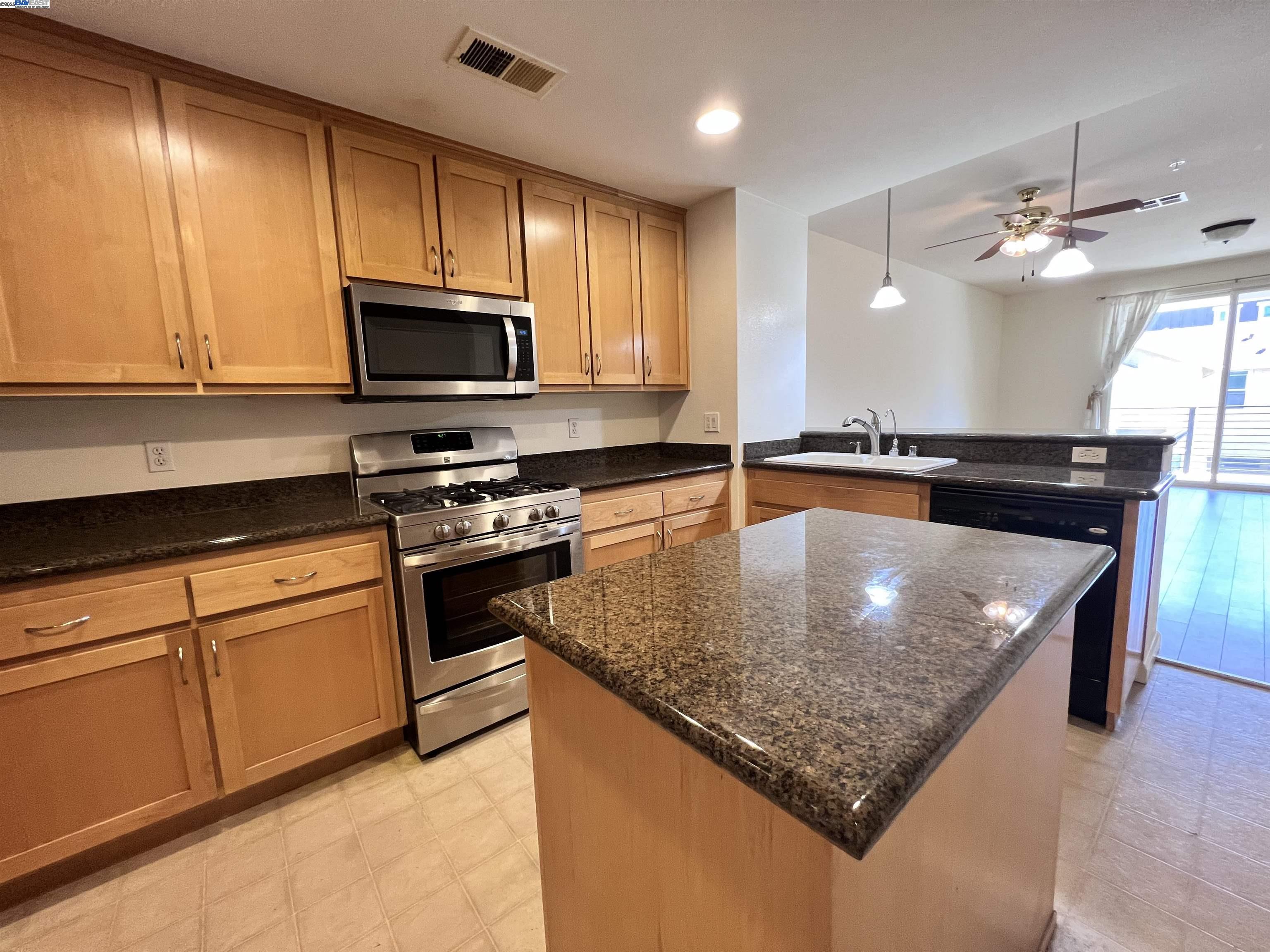 4331 Westerly Common Fremont, CA 94538 - Photo 9 of 24 a kitchen with stainless steel appliances granite countertop a sink a stove microwave and cabinets
