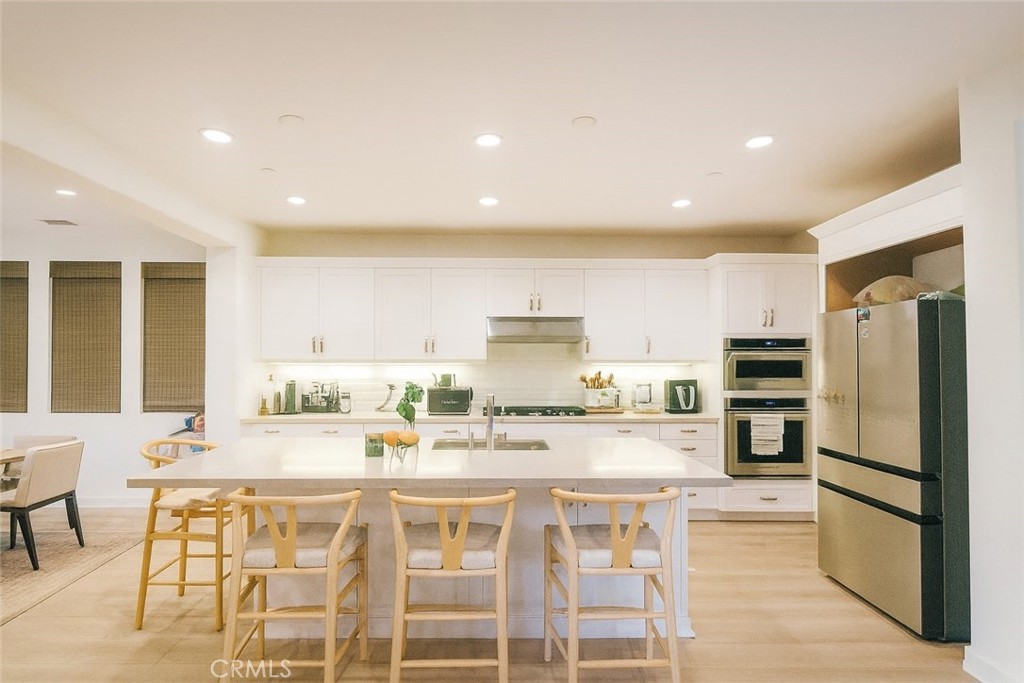 279 Barnes Road Tustin, CA 92782 - Photo 8 of 31 a kitchen with stainless steel appliances kitchen island granite countertop a refrigerator and cabinets