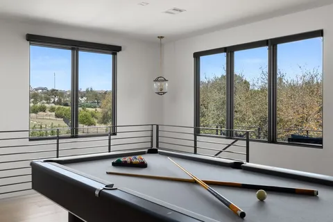 a room with pool table and windows