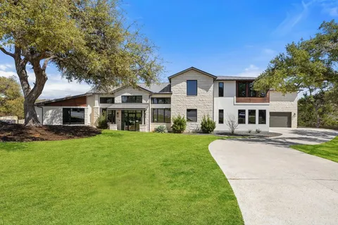 a front view of a house with a garden and yard