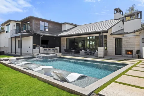 a view of a house with swimming pool and sitting area