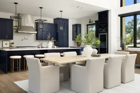 a view of kitchen with stainless steel appliances kitchen island dining table and chairs