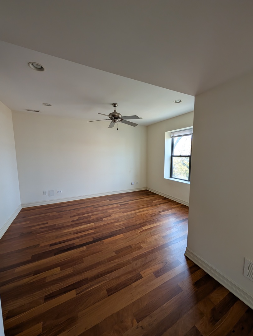 4345 North Sawyer Avenue, Unit A3 Chicago, IL 60618 - Photo 5 of 12 a view of empty room with wooden floor and fan