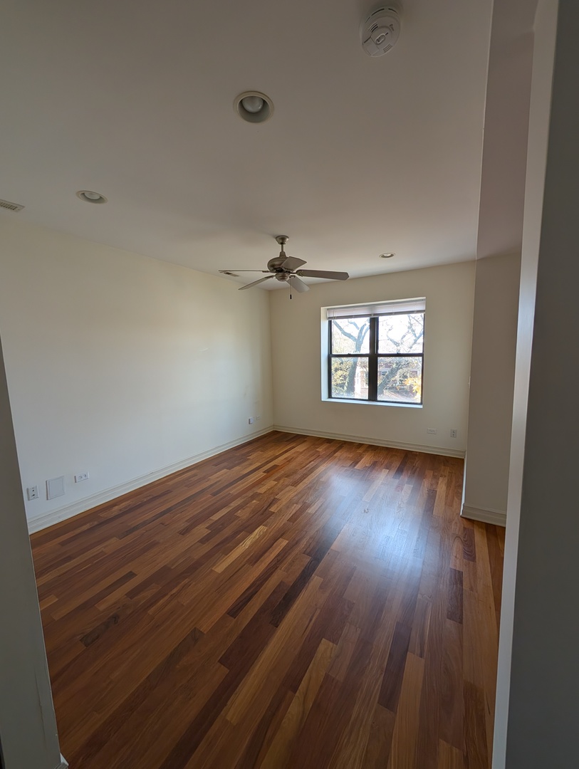 4345 North Sawyer Avenue, Unit A3 Chicago, IL 60618 - Photo 6 of 12 wooden floor in an empty room with a window