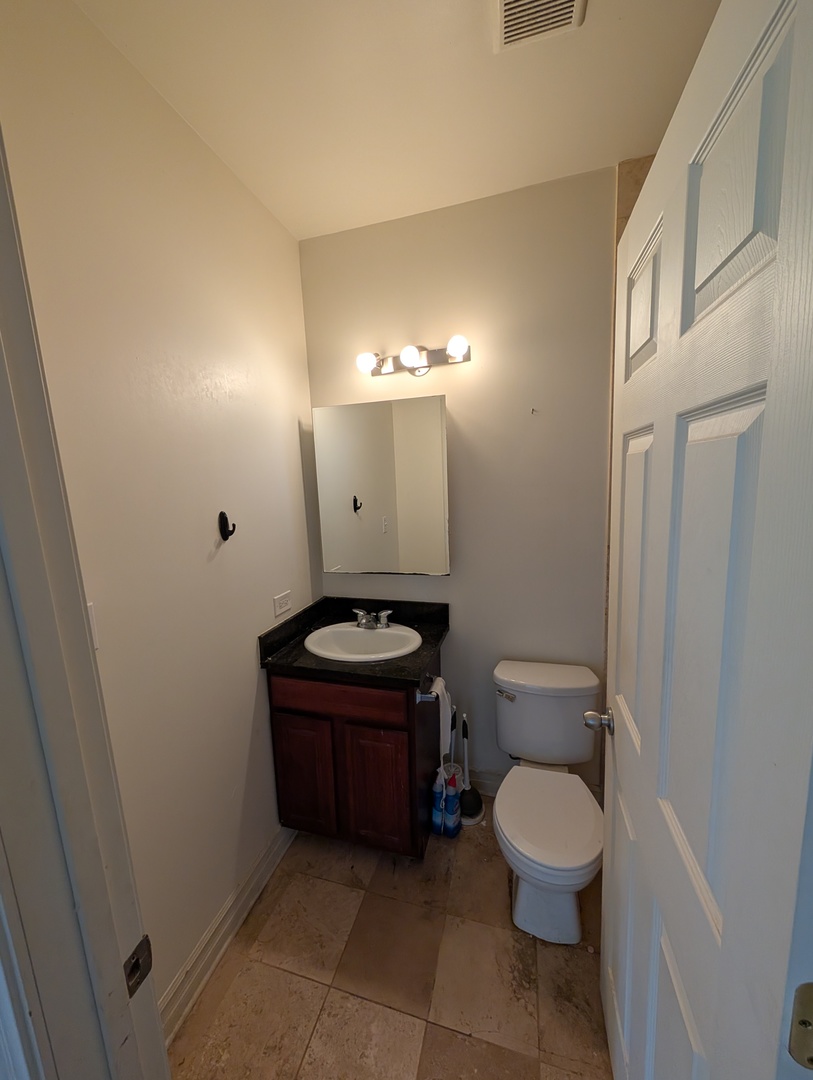 4345 North Sawyer Avenue, Unit A3 Chicago, IL 60618 - Photo 10 of 12 a bathroom with a toilet sink and mirror