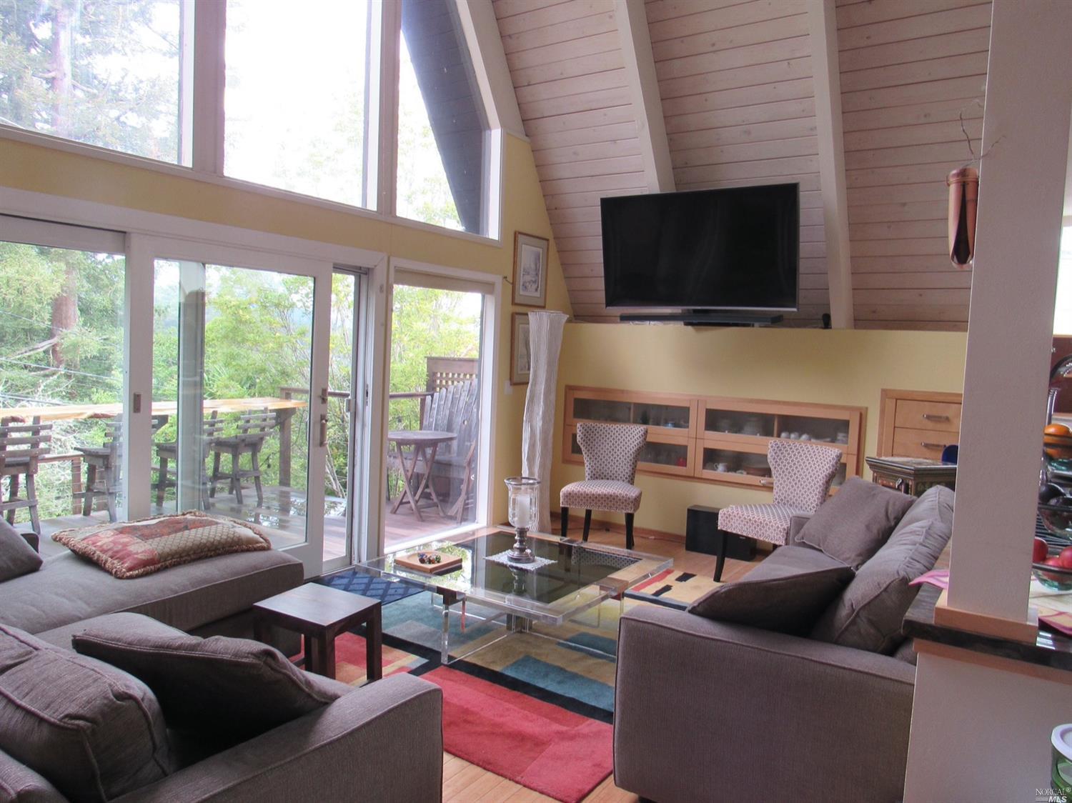 a living room with furniture a flat screen tv and a floor to ceiling window