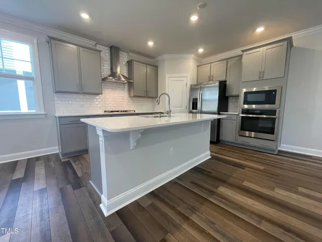 a large kitchen with stainless steel appliances granite countertop a stove a sink and a refrigerator