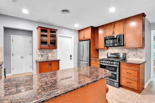 a kitchen with stainless steel appliances granite countertop a stove top oven a sink and a granite counter tops