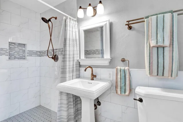 a bathroom with a sink a toilet and shower