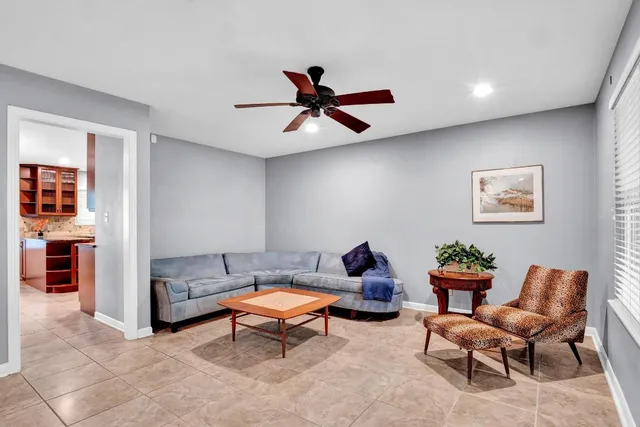 a living room with furniture and a ceiling fan