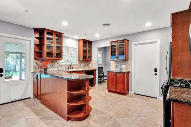 a view of kitchen with stainless steel appliances granite countertop sink and cabinets