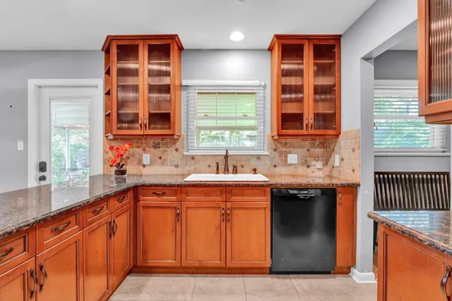 a kitchen with stainless steel appliances granite countertop a sink and a stove