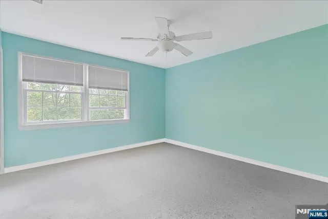 an empty room with a window and a fan