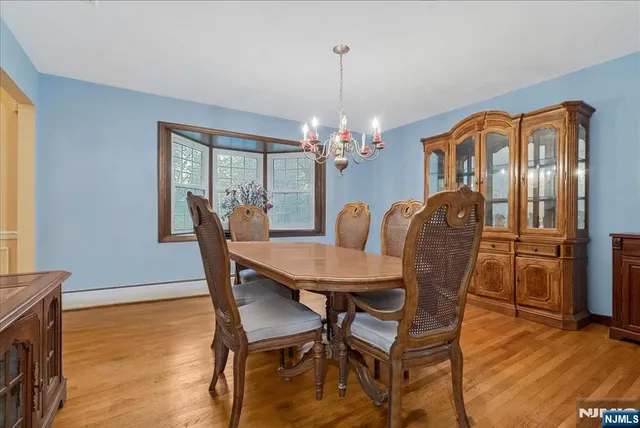 a dining room with furniture a chandelier and wooden floor
