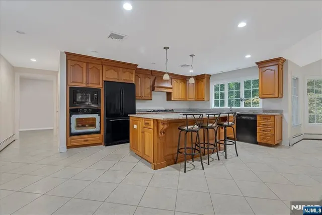 a kitchen with granite countertop a refrigerator and chairs