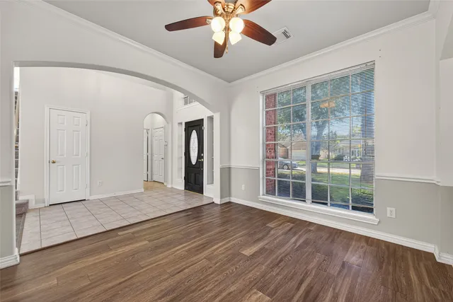 a view of an empty room with wooden floor fireplace and a window