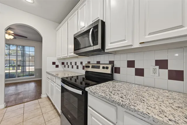 a kitchen with kitchen island a counter top space cabinets and stainless steel appliances