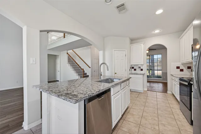 a kitchen with stainless steel appliances granite countertop a stove and a sink