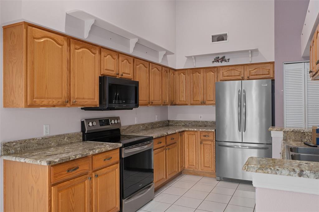 2321 Terrace View Lane Spring Hill, FL 34606 - Photo 13 of 41 a kitchen with granite countertop a stove top oven microwave and refrigerator