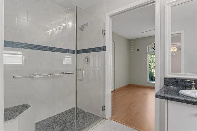 a bathroom with a granite countertop sink mirror and shower