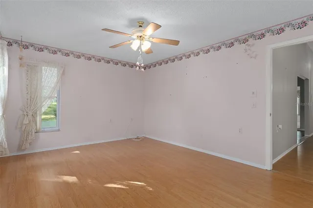 an empty room with windows and fan