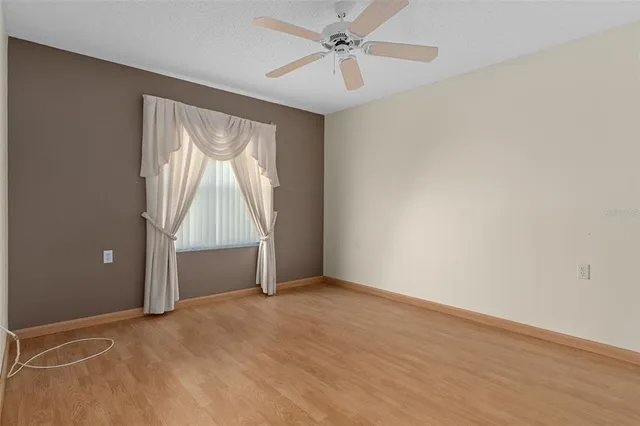 an empty room with windows and fan