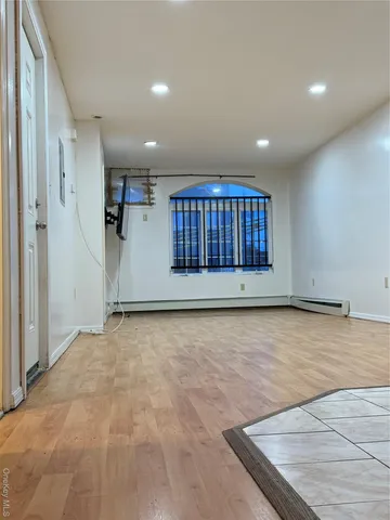 a view of an empty room with a cabinet and mirrors