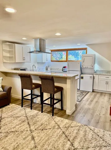 a kitchen with stainless steel appliances kitchen island a table and chairs in it