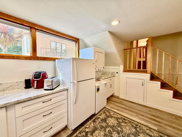 a kitchen with a refrigerator and white cabinets