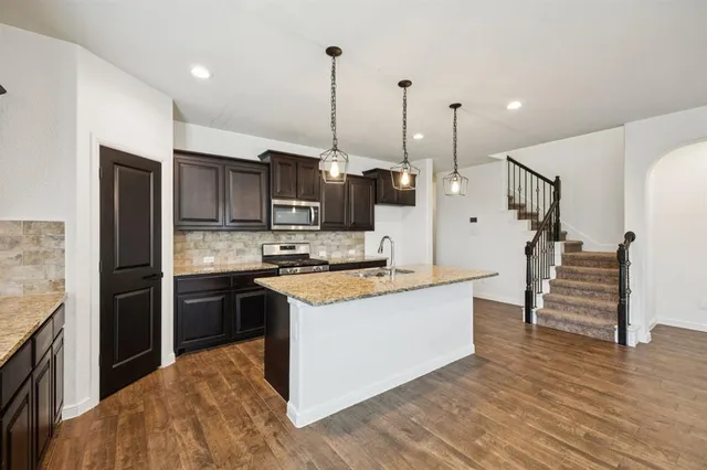 a view of a kitchen with a sink and a refrigerator