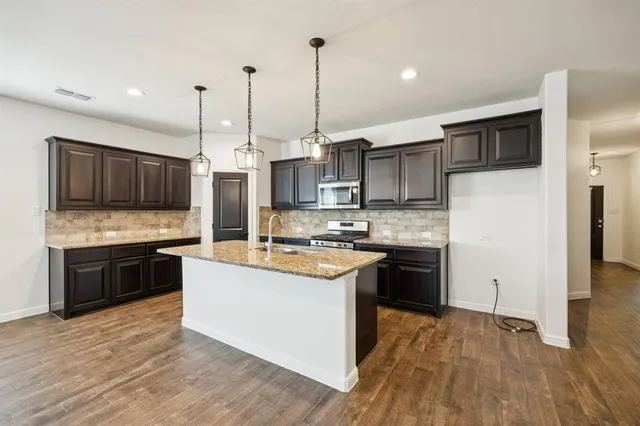 a view of an empty room with chandelier fan