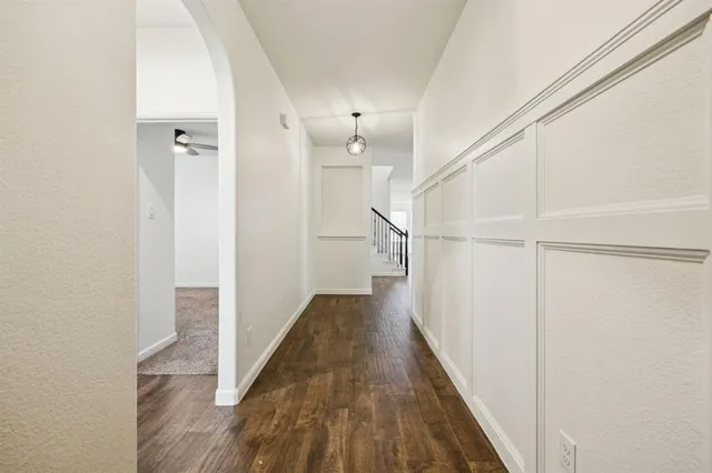a view of a hallway with wooden floor and staircase