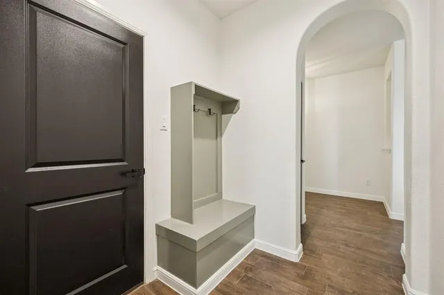 a kitchen with a stove a sink a center island and wooden floor