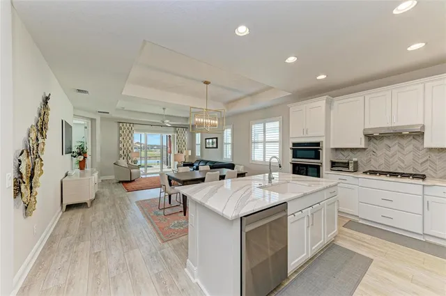 a large kitchen with kitchen island a sink stainless steel appliances and cabinets