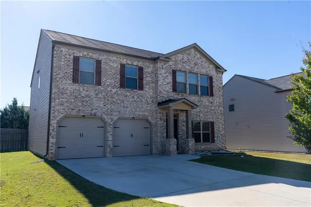 a front view of a house with a garden and yard