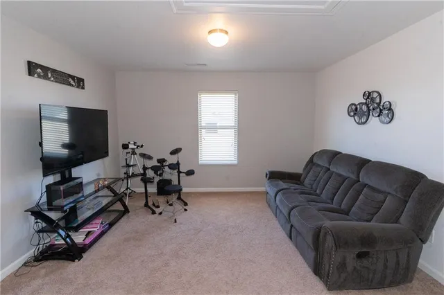 a living room with furniture gym equipment and a flat screen tv
