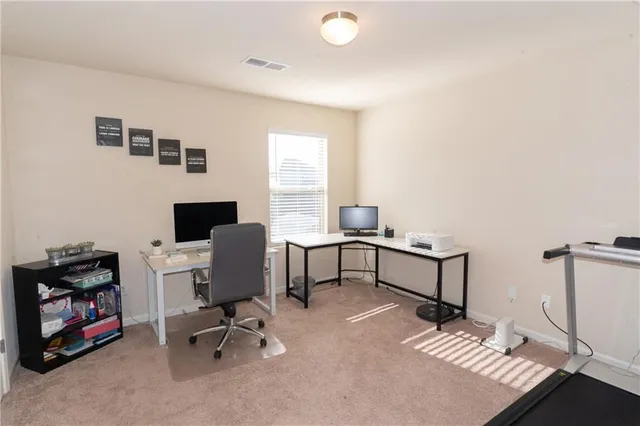 a view of a workspace with furniture and a window