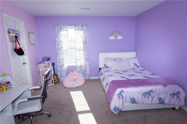 a bedroom with pink bed and window
