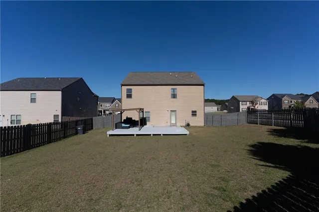 a view of a house with backyard and parking