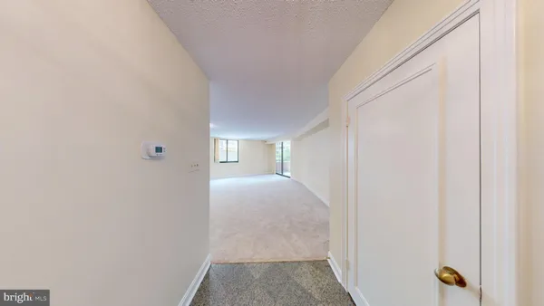 a view of an empty room with wooden floor and windows