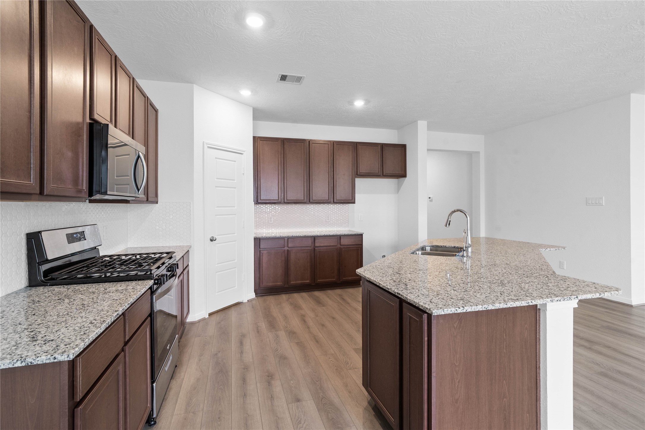 745 Imperial Loop Alvin, TX 77511 - Photo 17 of 29 a kitchen with kitchen island granite countertop a sink stove and cabinets