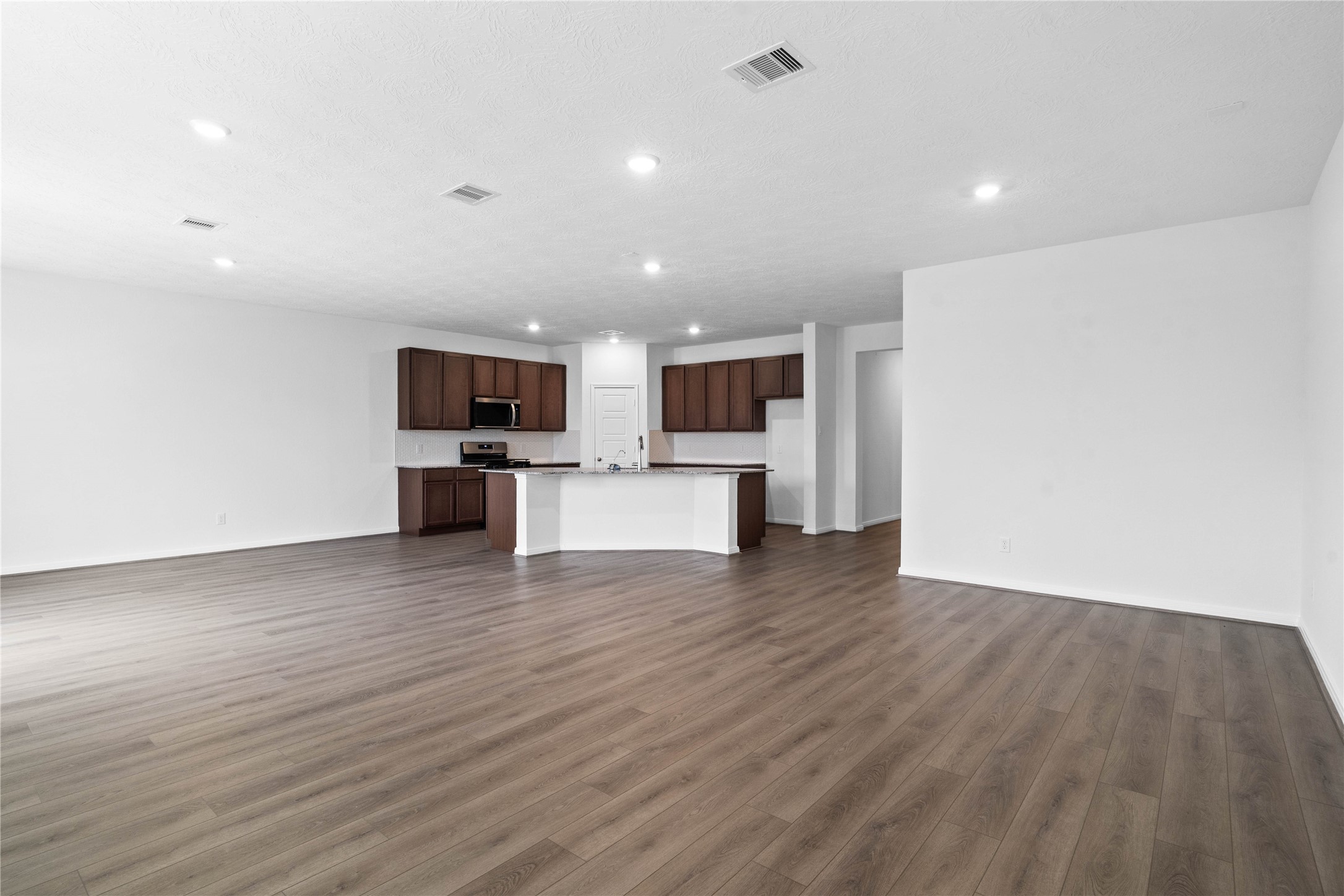 745 Imperial Loop Alvin, TX 77511 - Photo 22 of 29 a view of kitchen with microwave stove refrigerator and cabinets