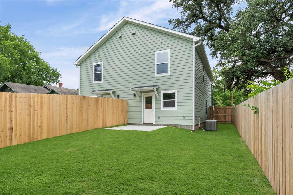 1536 Alexander Avenue, Unit A & B Waco, TX 76708 - Photo 6 of 30 Rear exterior featuring light green siding, a new wood fence, a concrete patio, and a grassy yard