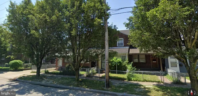 front view of a house with a yard and an trees