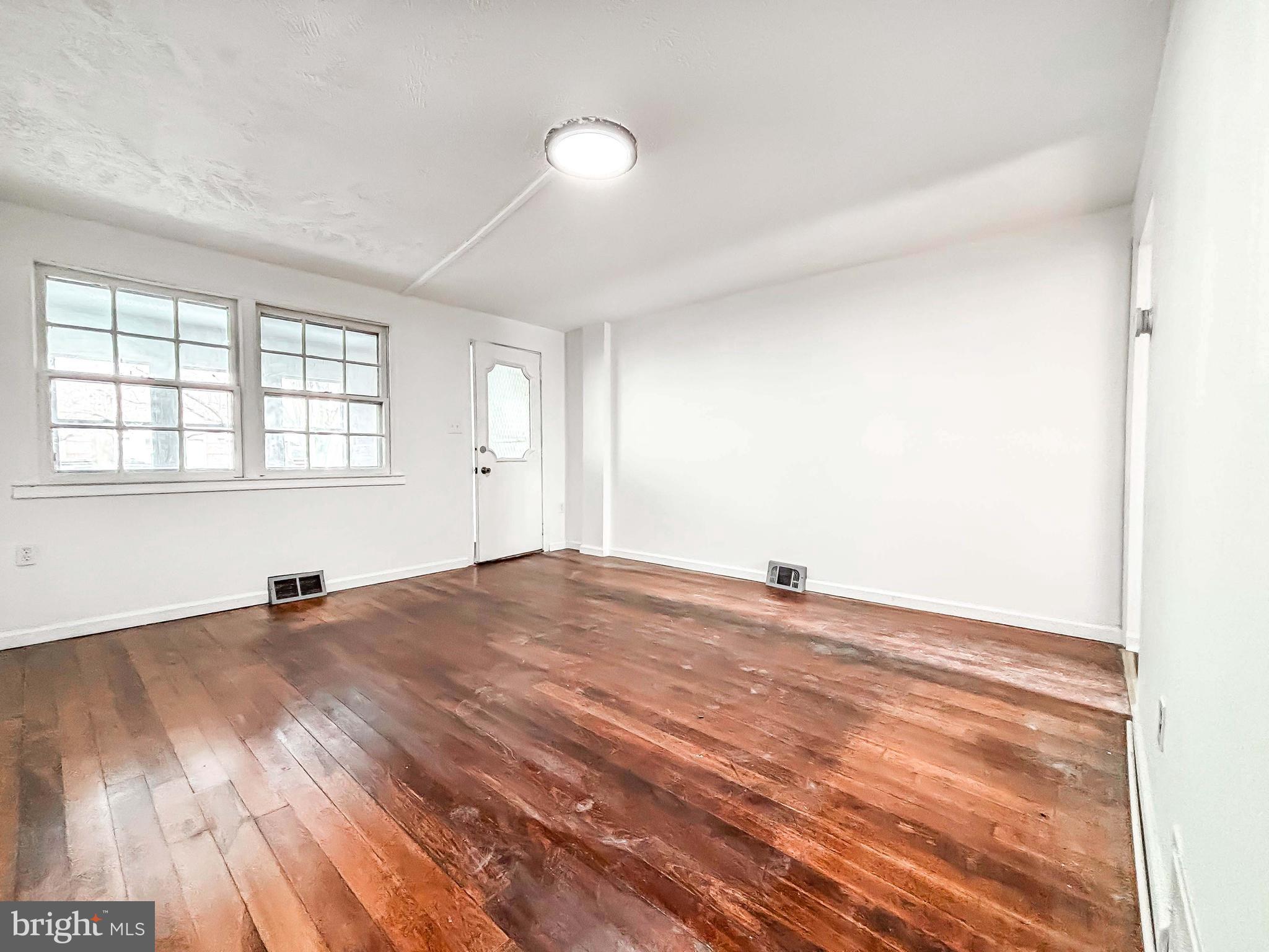 414 Avondale Road Dundalk, MD 21222 - Photo 5 of 33 an empty room with wooden floor and windows