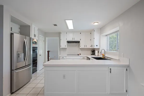 a kitchen with stainless steel appliances a refrigerator sink and microwave