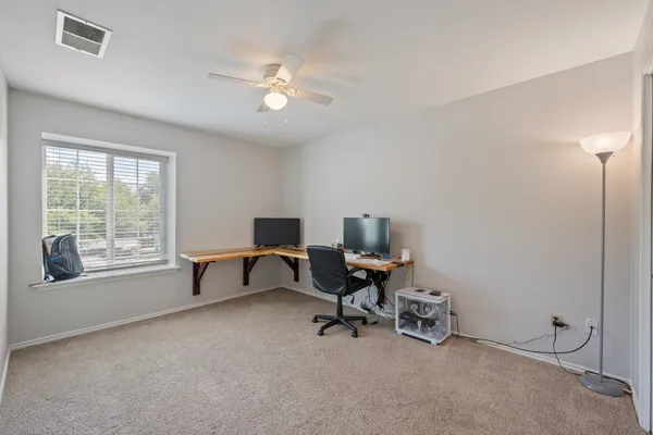 a view of a workspace with furniture and a window