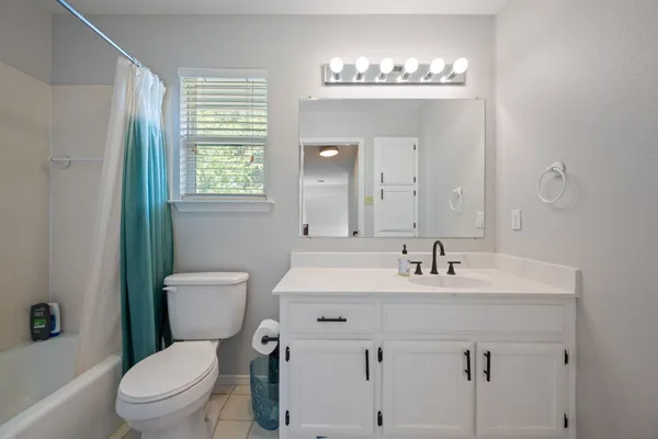 a bathroom with a sink toilet mirror and shower
